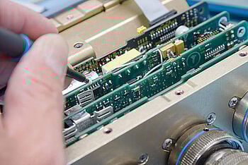 A technician testing and calibrating an oscilloscope