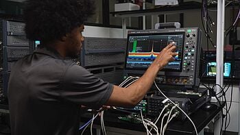 Engineer using an oscilloscope for signal analysis.