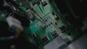 Close view of test probes contacting a circuit board in an automated test fixture